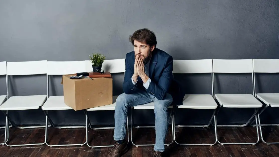 image of man who lost his job sitting on chair